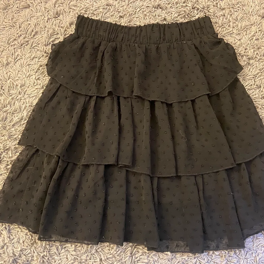 En svart volang kjol som jag köpt secondhand! Resår i midjan och prickig. Jag säljer denna för att den inte längre kommer till användning🌼. Kjolar.