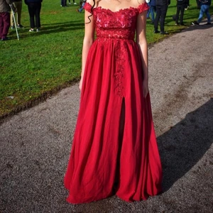 Vinröd balklänning med fint mönster  - Mycket fin balklänning. Använd 1 gång. Mycket bra skick. Köparen står för frakt. Ordinariepris 2500kr