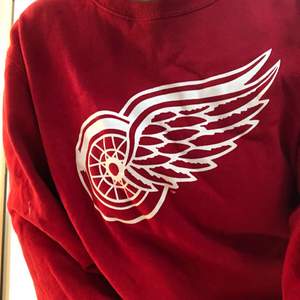 Röd sweatshirt med Detroit Red Wings loggan på, skön att ha på sig, använd få gånger