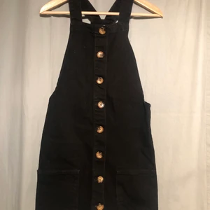 Hängselklänning med knappar i strl 34 - Fin hängselklänning i jeans med knappar i storlek 34. Köpt i London och är i väldigt fint skick 🌸