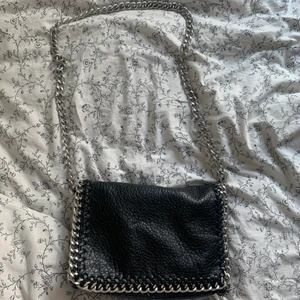 Tiamo väska - Svart väska från tiamo i mellan storlek. Den är i fint skcik men har en drag kedja trasig där bak men dragkedjan går fortfarande att dra igen även om hänget saknas! Därav priset🌸💗