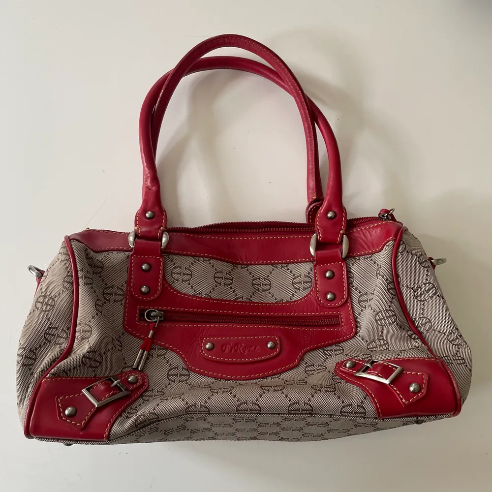 Grå handväska med röda detaljer! Köpt secondhand men superfint skick 💋. Väskor.