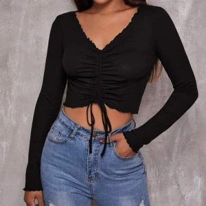 Enfärgad tröja med rynkad design med dragsko framtill och kråskanter  - En sån fin tröja som jag tyvärr bara använt ett par gånger. Snörena går att dra så tröjan blir korta eller längre. Väldigt skönt material och i god skick💕