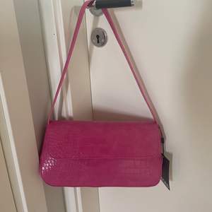 En rosa handväska från Nelly (tror jag), säljer pga att den inte kom till användning, prislapp och papper kvar i. Nypris för 250kr, säljs för 150kr. Perfekt till en exempelvis svart outfit för att få lite färg. 