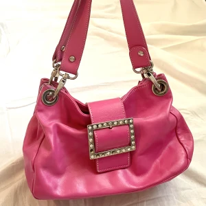 Rosa axelväska - Säljer denna fina handväska då den inte kommer till användning :) 🌟 Några stenar saknas som man ser på bilden men annars bra skick. 