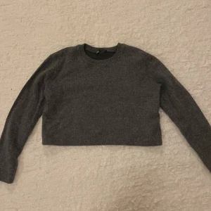 Stickad tröja - En fin grå croppad tröja, i stickat material. Köpt på Zara. Säljer för att jag inte använder den längre. Jättefint skick. Storlek S. Hör av er för mer information!