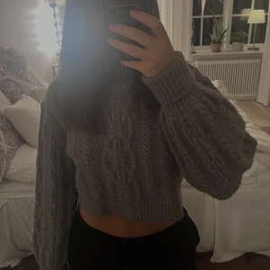 Stickad tröja - Croppad stickad tröja rån Nakd. Sparsamt använd. Superbra skick. På bilden är den uppvikt i ärmen. Fler bilder finns vid intresse! 