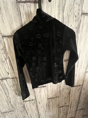 En svart Gucci tröja som är i mocka med en liten kragen. Fick den av en familjevän men har aldrig personligen använt. 
