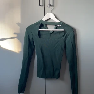 Grön långärmad tröja - Super snygg tröja från Zara i mörkgrön. Har en cutout vid bröstkorgen och dragkedja vid nacken. Använd 1 gång 
