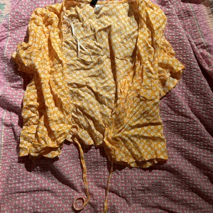 Blommig blus - Orange med vita blommor. Pris + frakt