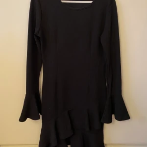Svart långärmad klänning - Svart långärmad klänning med volangdetaljer. Använd en gång 💞