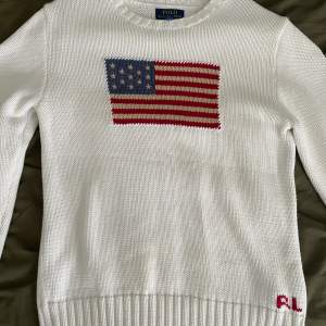”The iconic flag Sweater” Storlek XL i barn storlek sitter som en S/ liten medium.   Säljes pga hänger bara i min garderob  Fläck på ena ärmen (se bild 2)
