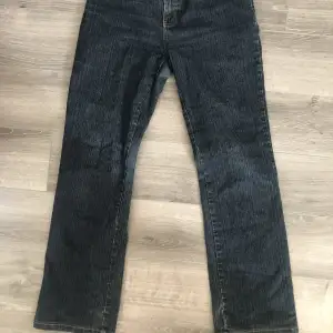 Mörkblå midrise bootcut jeans som är insydda i midjan