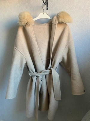 Kappa med päls - En beige kappa med päls köpt förra året. I bra skick inga skador. 