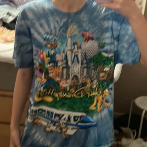 Disney T-shirt - En fin tröja från Disney Land! Det är bilder på nästan alla olika Disney karaktärer och en blå tiedye bakgrund💕