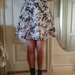 Rosa kjol - En A-line kjol med vita blad på en rosa bakgrund. Den har ett midjemått på 73 cm och den är lite för stor för mig som brukar vara en S/XS i storlek.
