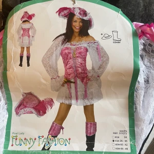 Halloweenkostym - Oanvänd halloween kostym köpt förra året. Rosa pirat där korsett, spetsklänning, pirathatt och ”shoecovers” ingår. Storlek 36/38. Köpt för 449:- Skriv privat för fler bilder.