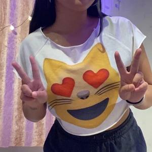Vit magtröja tshirt med hjärtögon katt emoji på - Köpte den på resa i Spanien typ 8 år sen, passar mig fortfarande men säljer för har inte använt den sen dess, passar storlek S-L, jätte söt lowkey sårar mig att sälja 🥲😻