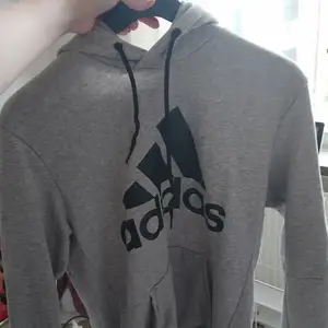 En grå Adidas hoodie som är använd ungefär 3 gånger. Orginalpriset är ungefär 500 kronor. 
