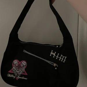 Väska - Säljer denna söta svarta HIM väska med tryck på framsidan. Kan posta eller mötas upp i Stockholm ❣️