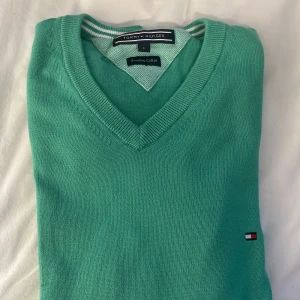 stickad V neck - stickad långärmad tröja från tommy hilfiger, knappt använd, använd ca 3 gånger. liten fläck längst ner på armen (bild 3) använd gärna köp nu elelr skriv :)