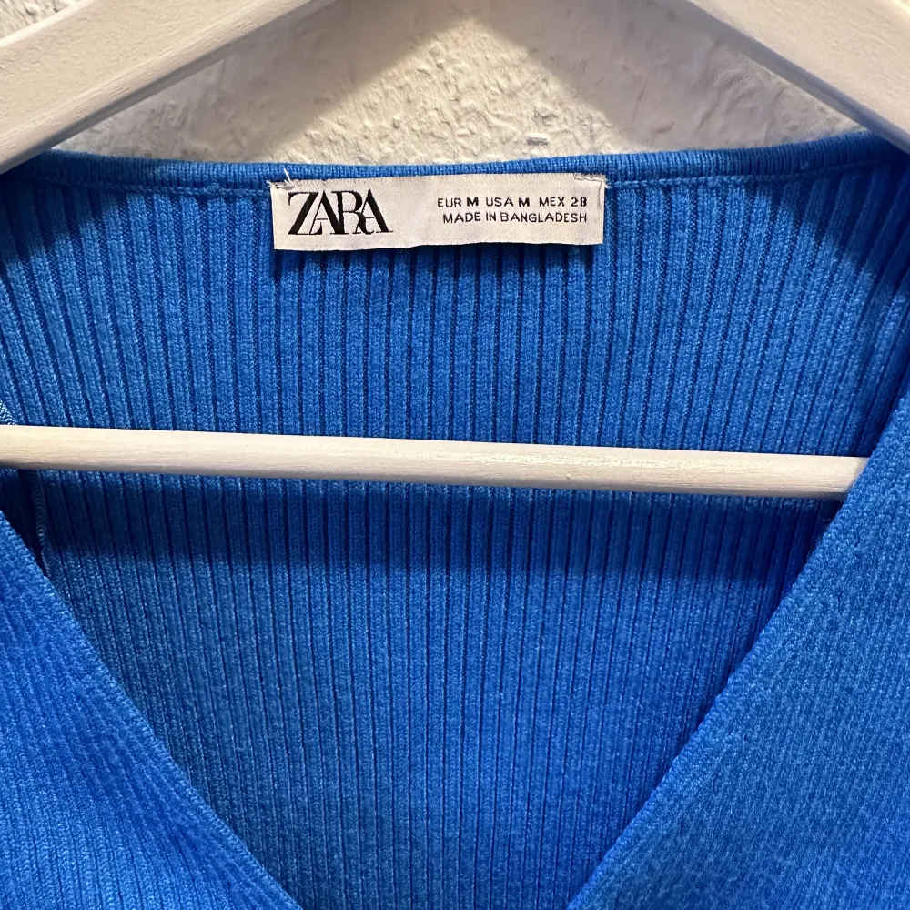 Croppad stickad tröja från Zara i jättegin blå färg med knytdetalj framtill som kan anpassas! Endast använd en gång så i superfint skick☺️. Toppar.