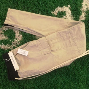 Essentials byxor  - Beigea Essentials cargo pants i Small, oanvända