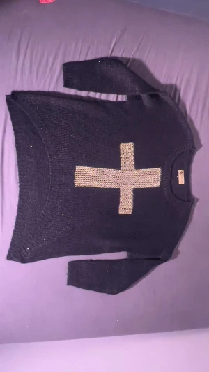 Stickad Paljett tröja  - Stickad tröja med svarta paljetter och guld kors 