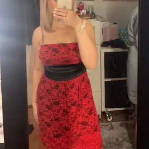 En fin röd klänning med mönster med rosett där bak