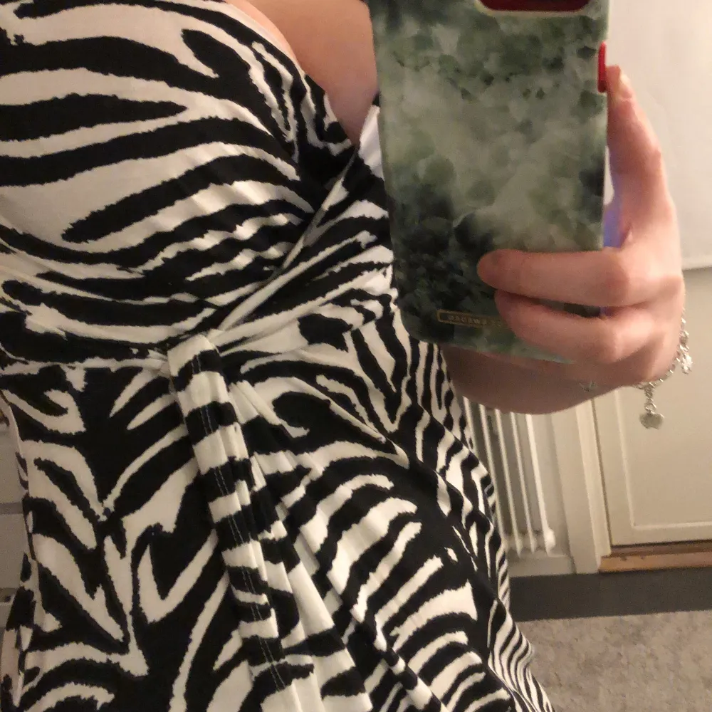En super skön zebramönstrad klänning som aldrig kommer till användning då jag inte är ett stort fan av mönster, v-ringad och har nån sorts ”knut” på ena sidan så den sitter åt lite finare . Klänningar.