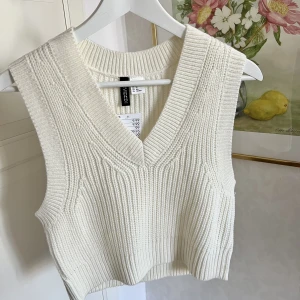 Krämvit stickad väst - Krämvit stickad väst från H&M. Aldrig använd, och lappen sitter kvar! I storleken XS💖