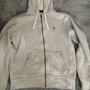 Ralph Lauren - Säljer min gråa zip Hoodie från Ralphs lauren nu, säljer pga att storleken är för stor för mig. Nypris är 1700 och jag säljer för 650kr. Köpta på Care of Carl i vintras.