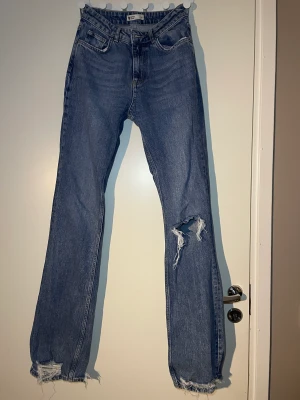 Lågmidjade Gina tricot jeans - Säljer dessa super fina lågmidjade jeans från gina tricot. Sitter tight runt lår och rumpa och går sedan ut ner mot fötter/vaderna! Skit snygg passform och jäättefin blå färg som är riktigt fina till ljusa färger😍 Storlek 34 men skulle säga 34-36