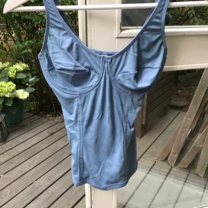 Vintage korsett-liknande linne - Jättefint ljusblått linne från 90-talet, är lite som shape-wear då det ger illusionen av en timglasfigur men inte alls så tight & väldigt stretchigt. Har inbygda byglar men inte vaddering.  Köpare står för frakt eller möts upp i Stockholm innerstad