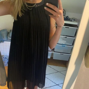 svart kort klänning - Säljer min plisserade klänning från ellos. Köptes för flera år sedan. Den hr en liten glitter kant där uppe. Använd fåtalgånger, passar mig på 167