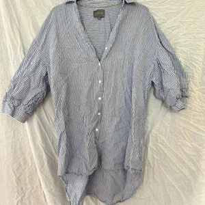 Blå randig strandkläning - En lättare blus/klänning att ha över jeans eller på stranden. Använd 5 gånger. Jätte lätt och skönt material. Lite finare i texturen. 