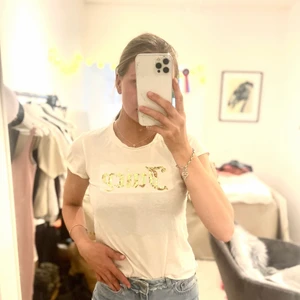 Juicy t-shirt  - Vit t-shirt med ”Juciy” i guldiga paljetter 