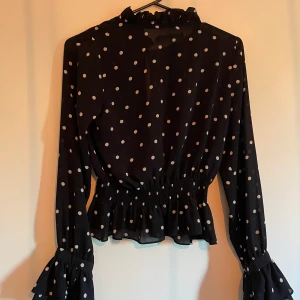 Blus - En svart prickig blus. Endast använd några få gånger. Storlek:S.