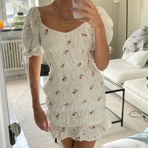 Blommig klänning - Vit klänning med blommor från Missguided. Använd en gång, liten fläck på bröstet som knappt syns. Ääälskar denna men använder tyvärr inte den.