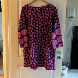 Klänning från Marimekko - Klänning från Marimekko, lila med rosa prickar, strl 38, bomull, blixtlås i rygg, fickor i sidsöm, knapp vid ärmslut Köpare står för frakt
