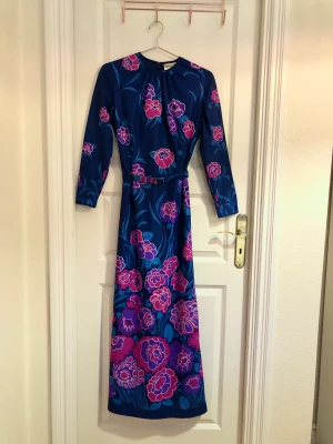 Blå Vintage klänning 1900-tal - Vintage klänning med tillhörande skärp i super fint skick från engelska märket Ladies Pride. Gamla storlekar som är små, i dagens mått en storlek SMALL och inte medium som lappen hänvisar. 