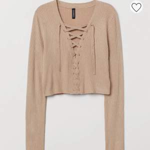 En snygg beige kort tröja med snörning fram Från H&M Väldigt fint skick då den bara är testad (: