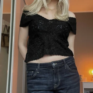 Spetstopp - Svart spetstopp som går att ha som linne och som offshoulder topp. 