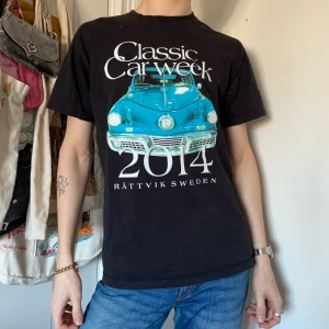 Svart graphic tee t-shirt turkos bil text  - Svart graphic tee med stort tryck på framsidan av en turkos bil och text köpt på second hand 🛻🛻 Älskar att trycket ser så vintage ut och att det tar upp hela framsidan! Perfekt passform och så snygg till stora jeans eller cargobyxor!! 🦕