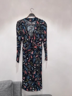 Klänning  - Superfin klänning med axelvaddar och skärp i mycket bra skick 