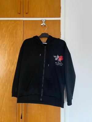 Hoodie  - Svart hoodie med text på framsidan, i storlek L men passar mer M. Endast använd en gång 