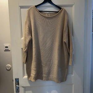 Lång stickad tröja från acne - Lång stickad tröja från acne med dragkedja och snöre på ryggen