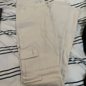 Cargo byxor  - Skit snygga beiga cargo byxor, aldrig använt då de va för stora och hittade inte kvittot.Säljer för 250 Priset går att diskutera. Passar s och m då de är stretchiga. Inte tajta på. Går över skorna. 