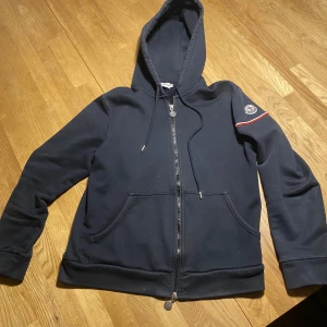 Moncler zip-hoodie - Säljer min moncler zip-Hoodie för den inte passar längre den är i storlek M man passar S/XS  den är självklart äkta skriv för flera bilder. Skick 9/10 köpt av en privatperson som säljer mycket dyrar kläder. Priset kan diskuteras vid snabb affär 