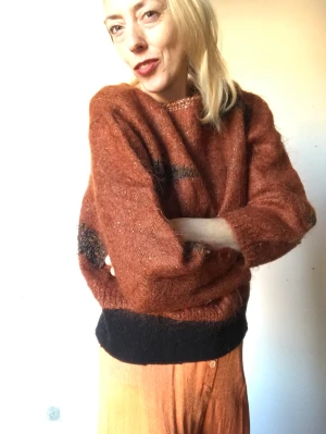 Stickad tröja  - Ur snygg stickad tröja i Kamel färg. Känns och ser ur som mohair blandning. Lite sliten i mudden vid midjan. Annars i fint skick!  Midja 108 cm Byst 86 cm Längd 52 cm Ärm 38 cm Axel  16 cm 